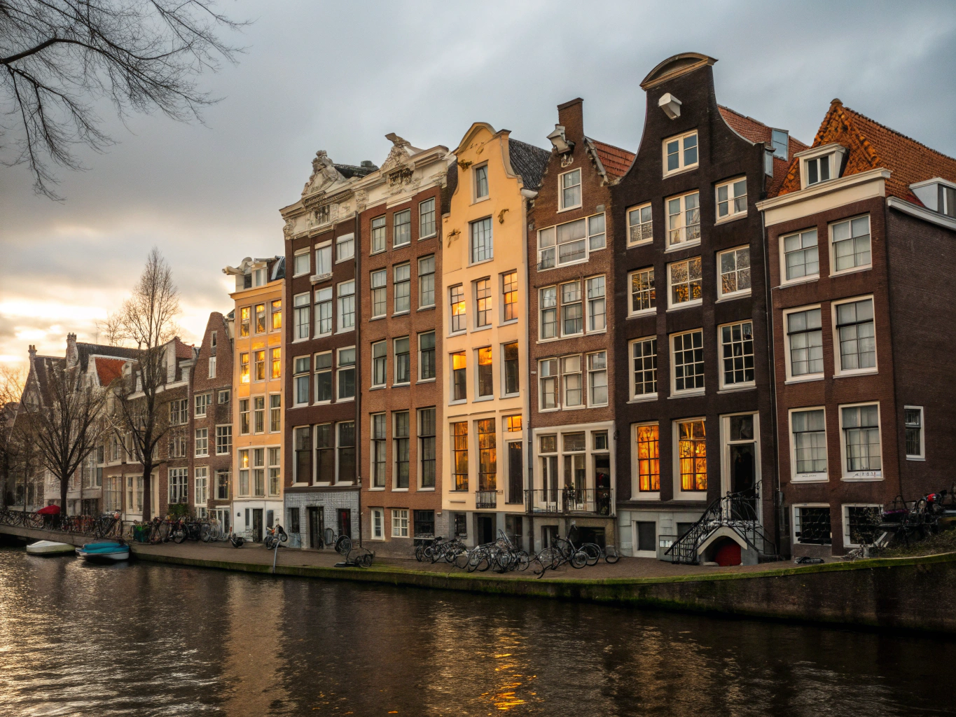 Historic gabled canal houses and bicycles on arched stone bridges along Prinsengracht