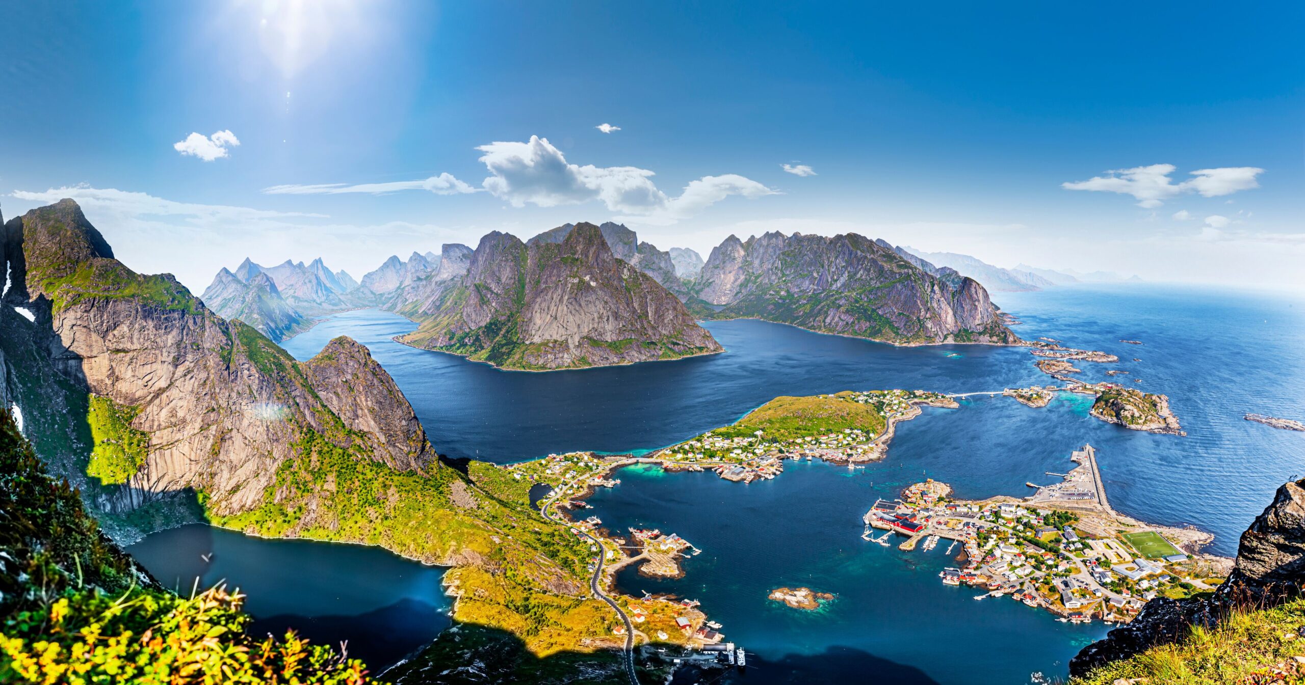 Panoramic view from the Reinebringen trail summit looking down over Reine village and its turquoise fjords