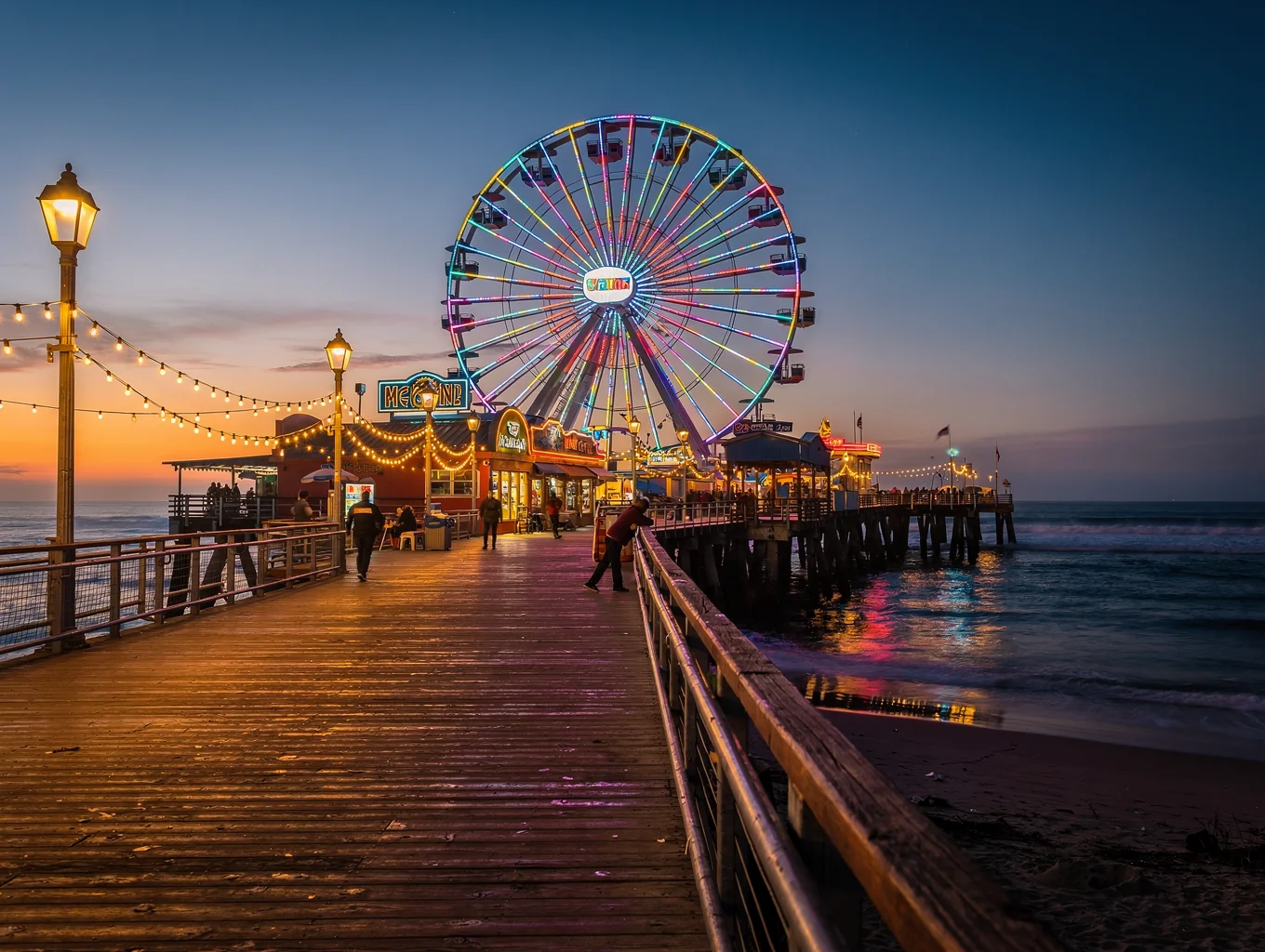 Santa Monica Pier illuminated over the Pacific ocean waves