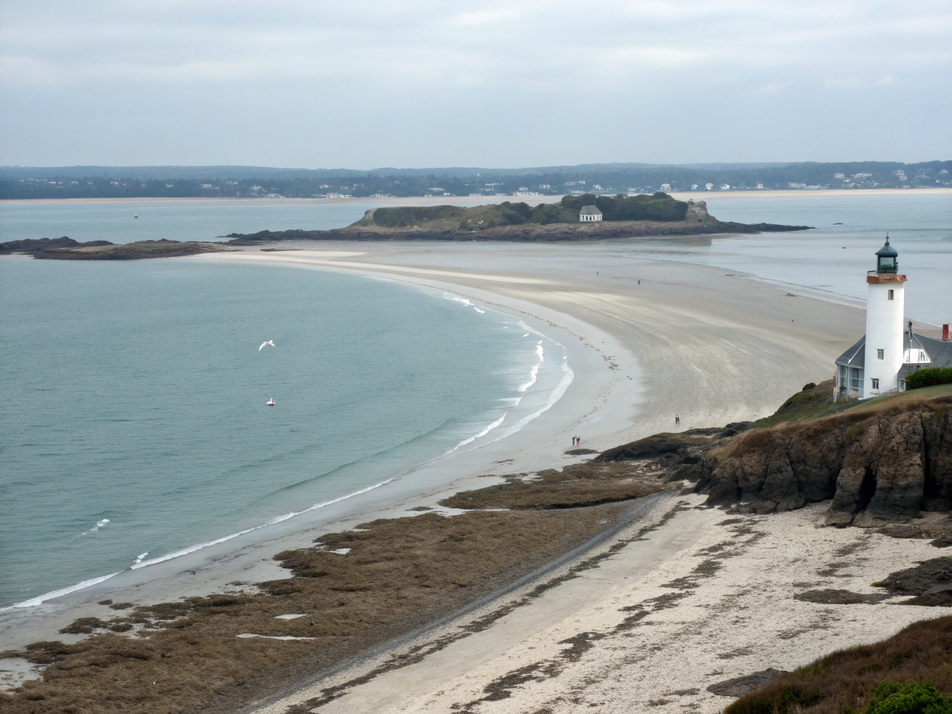 Rugged rocky Brittany shoreline with historic granite building at high tide