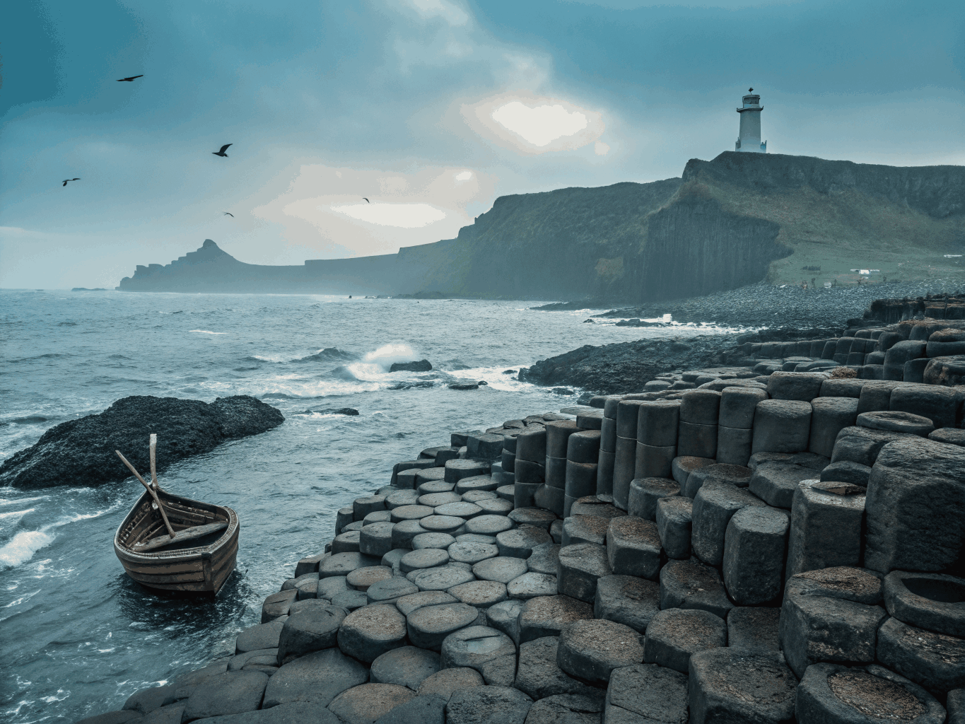Sekskantede basaltsøyler som møter bølgene ved Giant's Causeway i Nord-Irland
