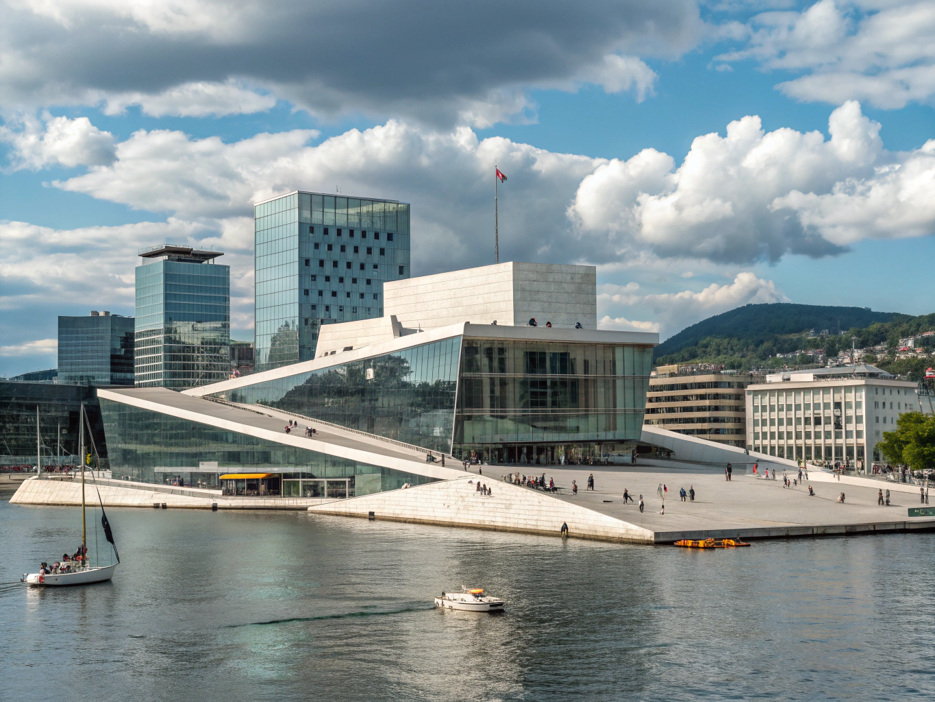 Modern white marble and glass architecture alongside the shimmering promenade of the Oslofjord