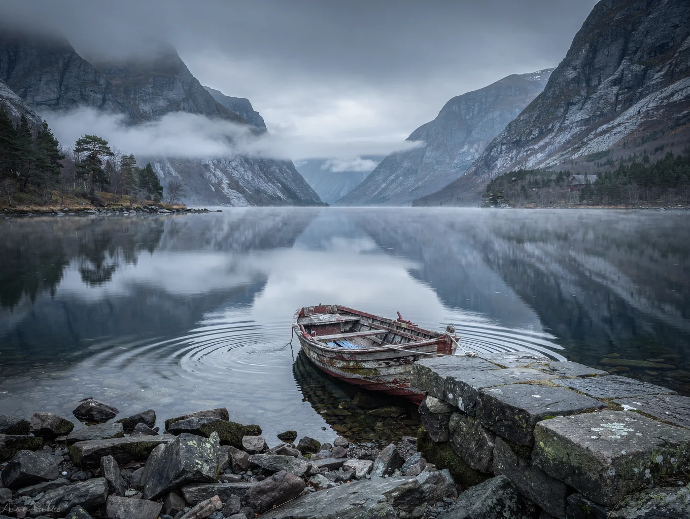 Deep blue fjord waters reflecting sheer mountains in Norway