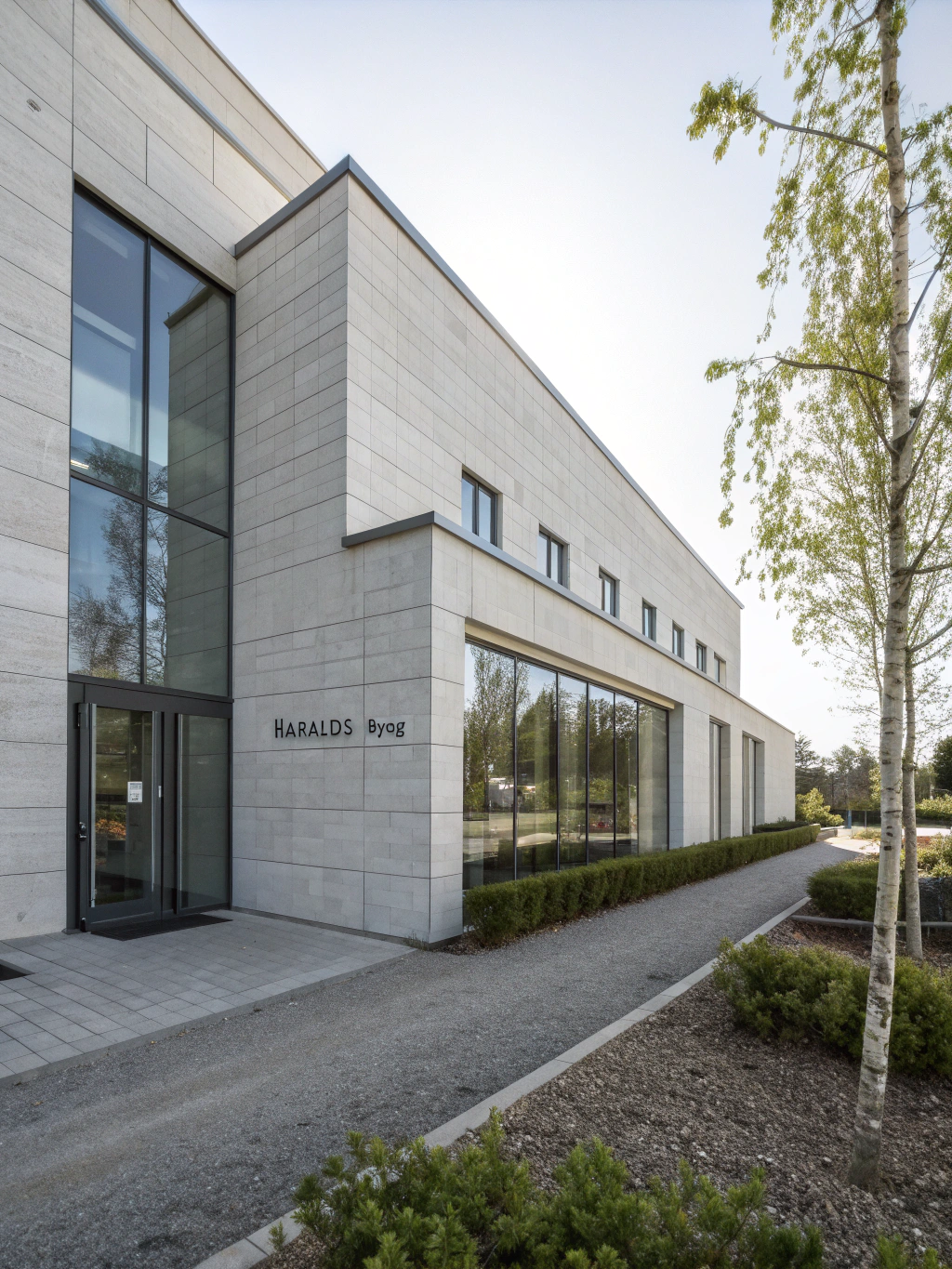 Modern white marble and glass architecture alongside the shimmering promenade of the Oslofjord