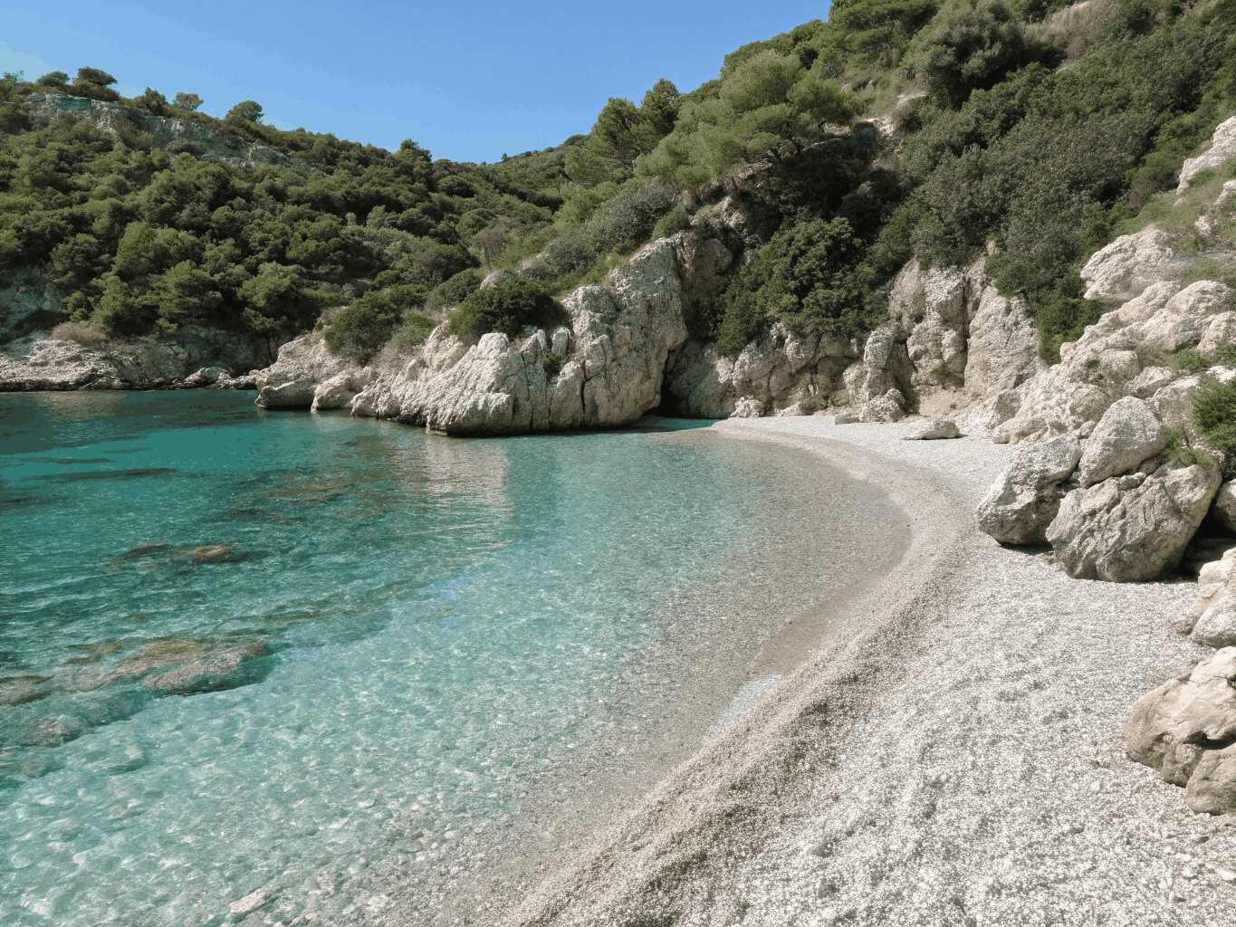 Quiet pebble bay with fortified stone towers in the Peloponnese