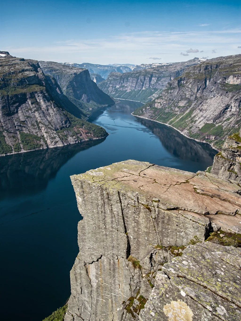 Dramatic vertical granite cliff face of Preikestolen overlooking the tranquil depths of Lysefjord