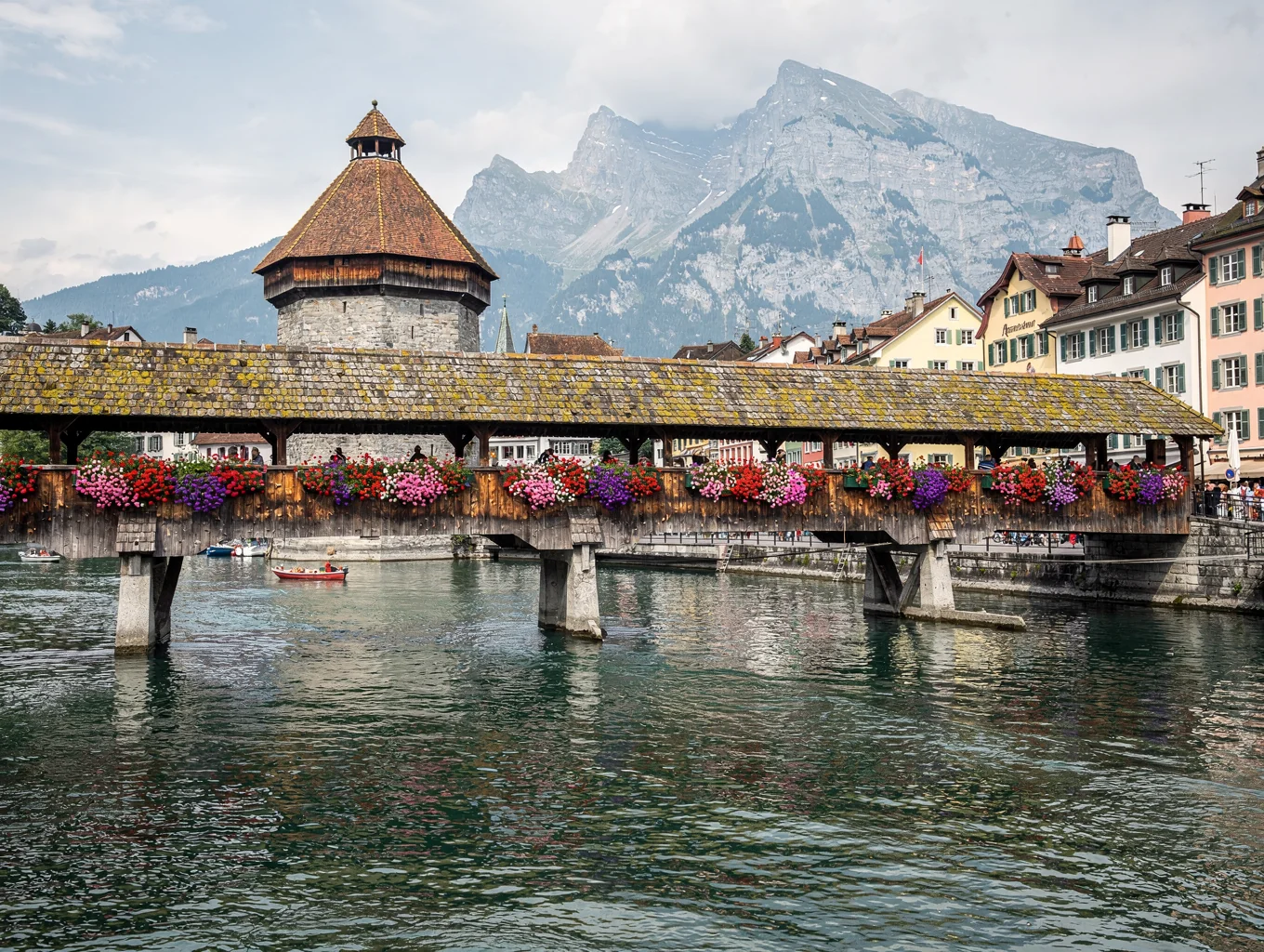 Historic wooden Kapellbrücke adorned with flower boxes over the river in Lucerne