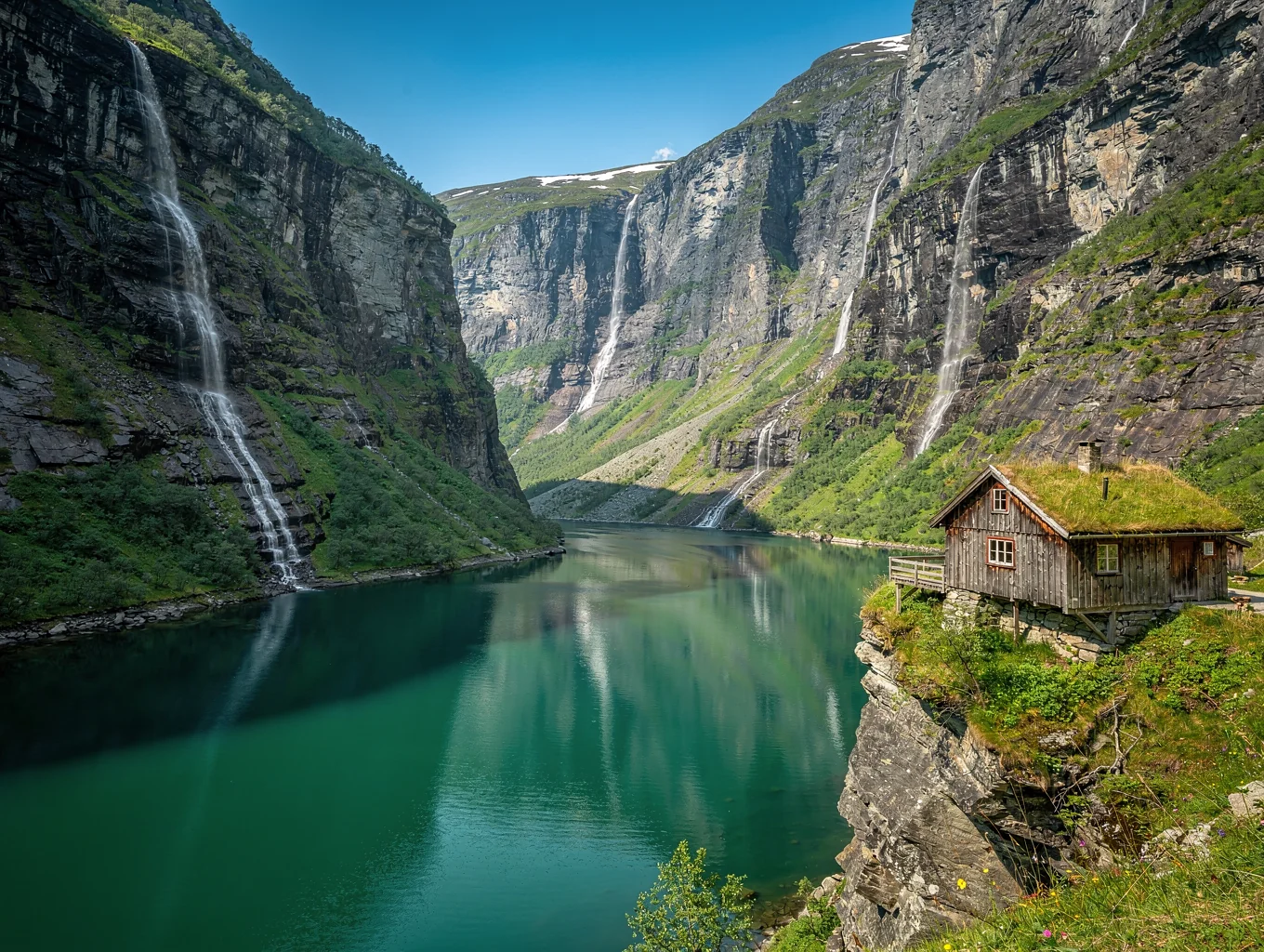 Deep emerald waters of Geirangerfjord framed by towering rock faces