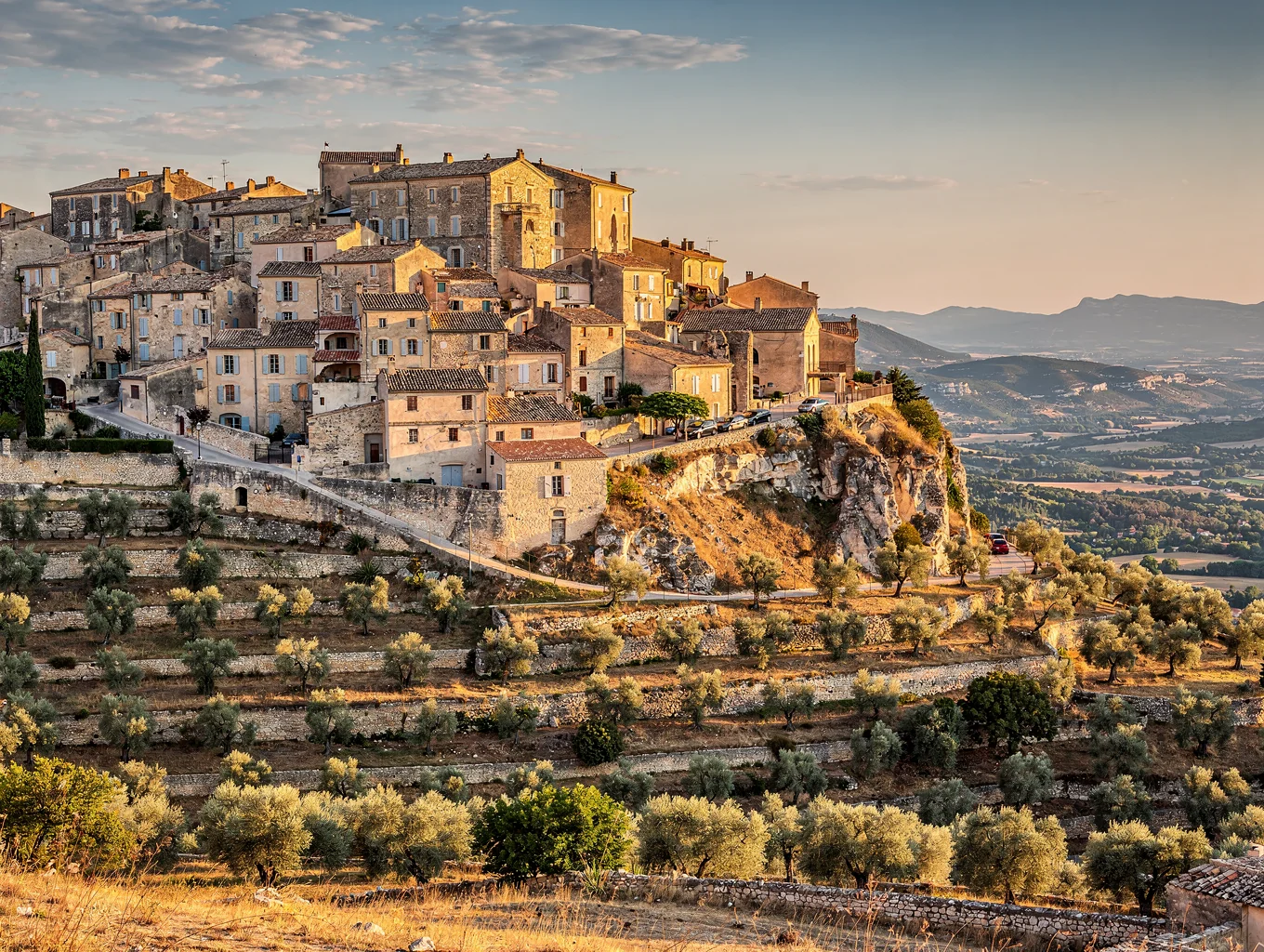 Stone village of Gordes perched high over the sunlit Luberon valley