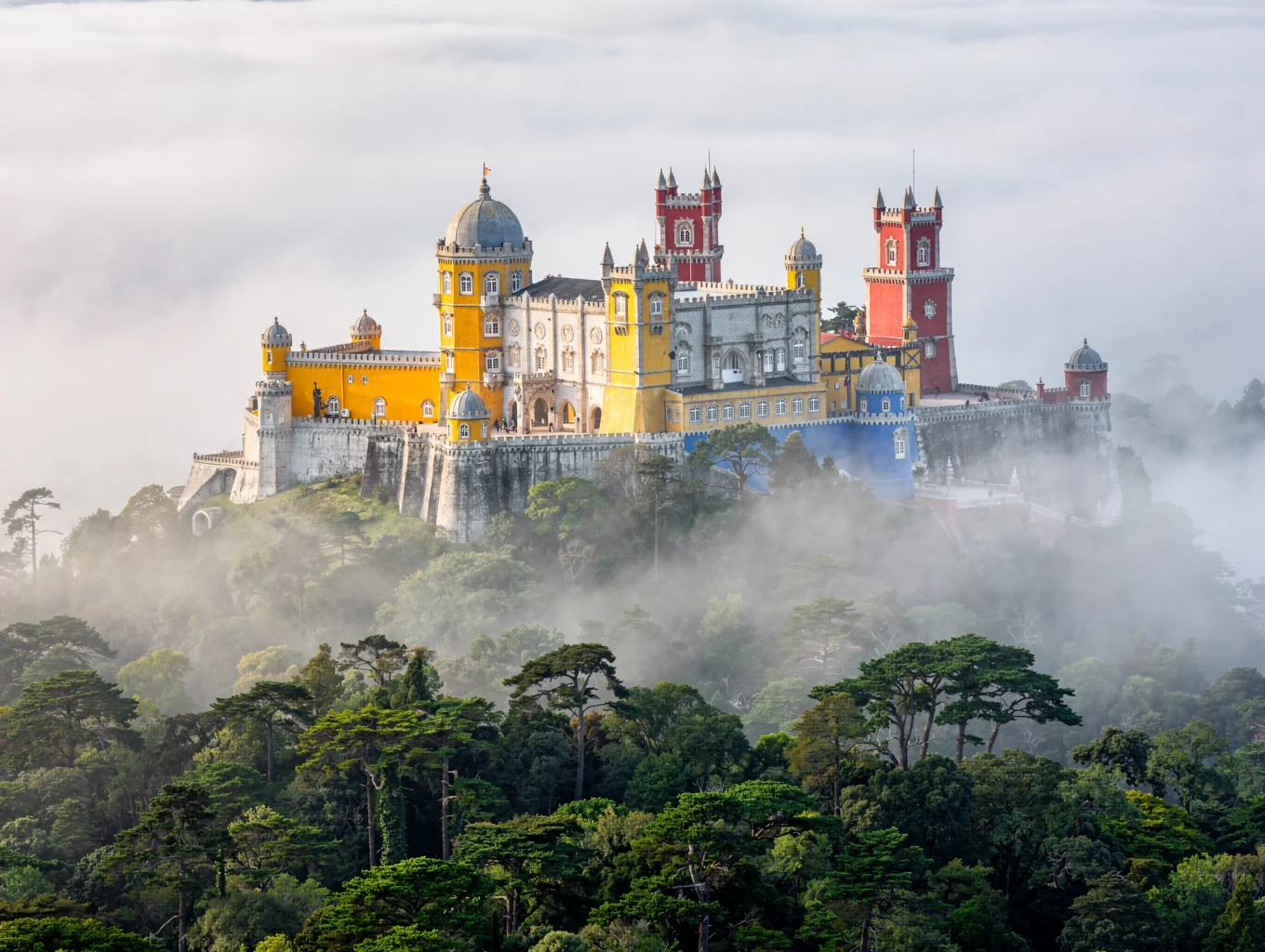 Eclectic towers and terraces of Pena Palace rising from coastal pine woodlands