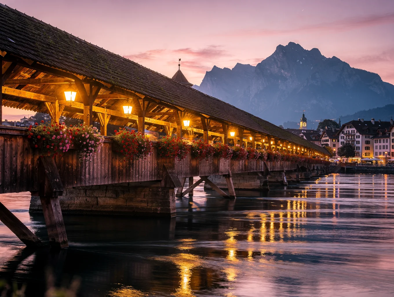 Covered wooden bridge with flower boxes lit under a violet evening sky