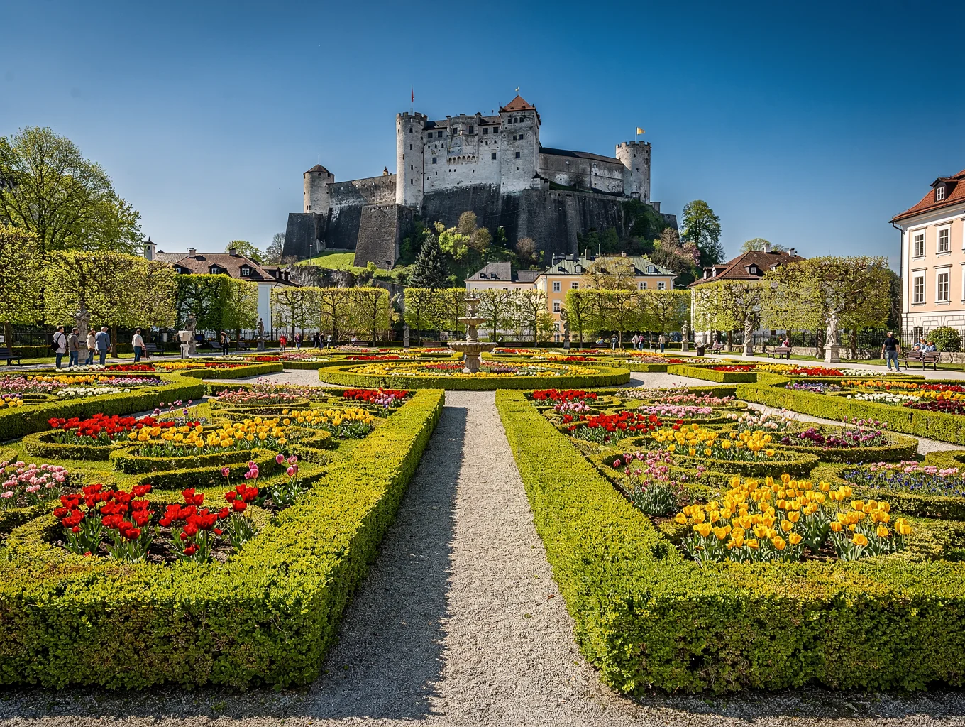 Formal manicured palace gardens leading the eye to a hilltop fortress