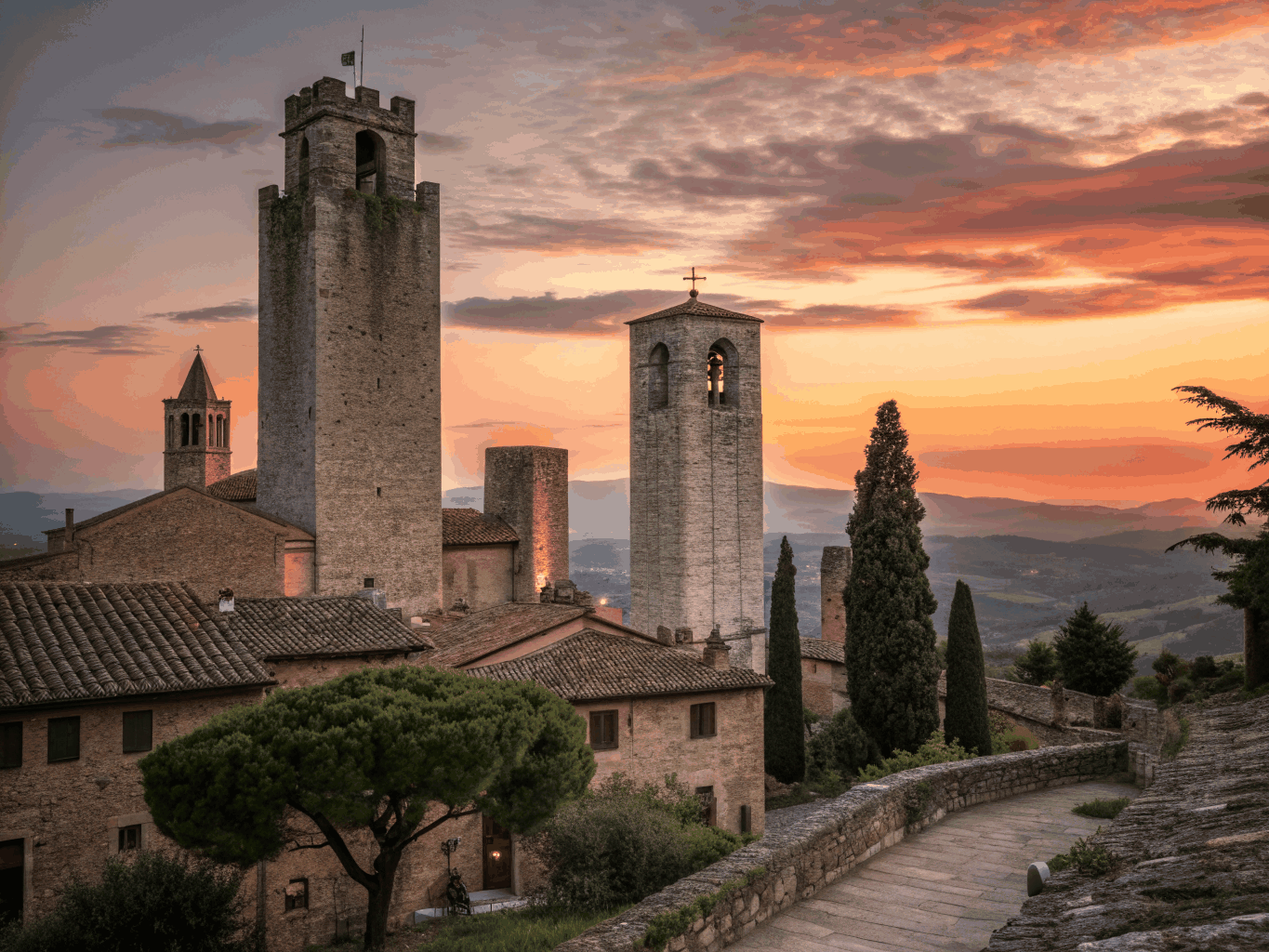 Stone medieval tower houses rising above golden Tuscan farm fields