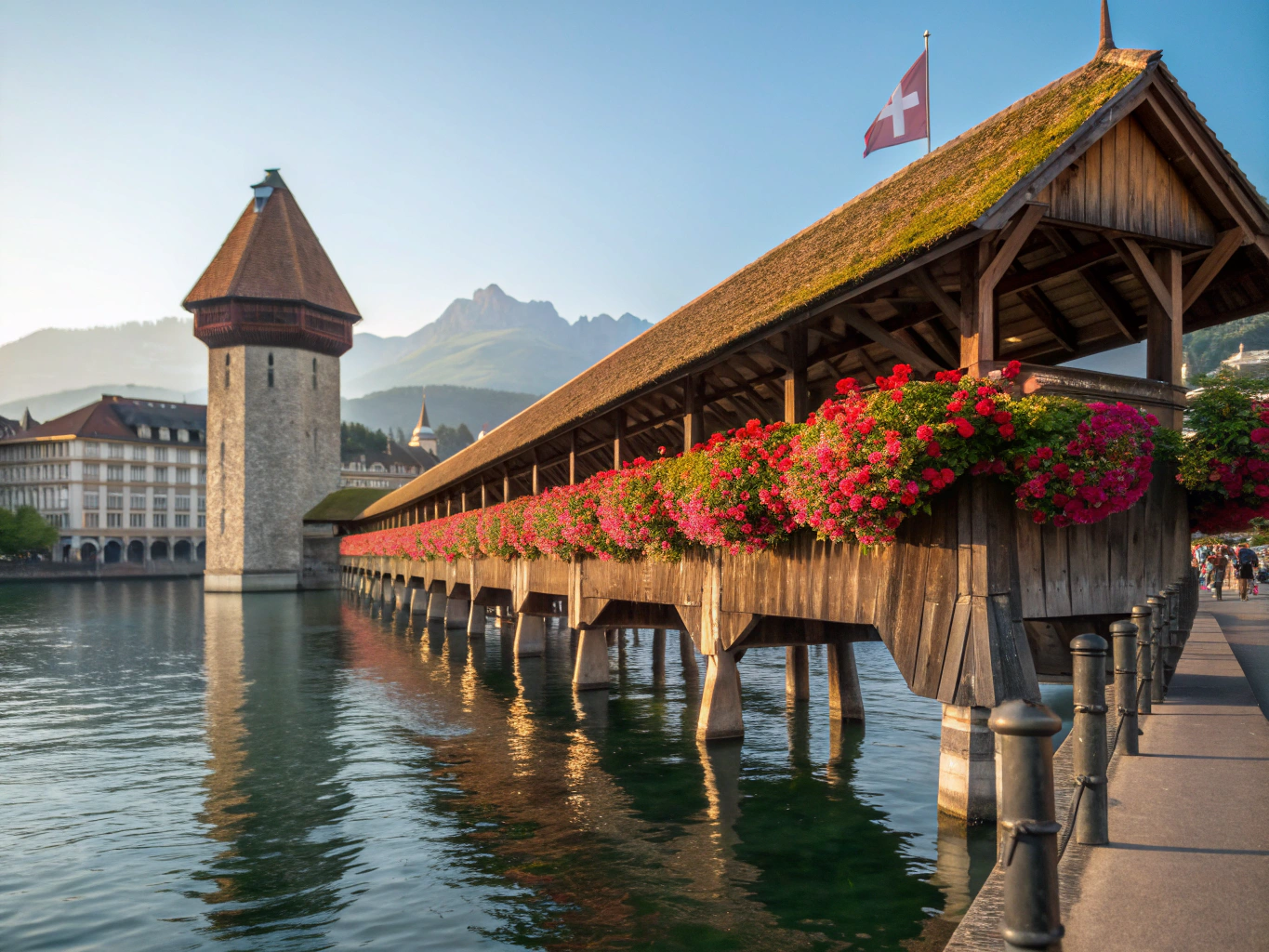 Covered timber bridge crossing the river in Lucerne against mountain peaks
