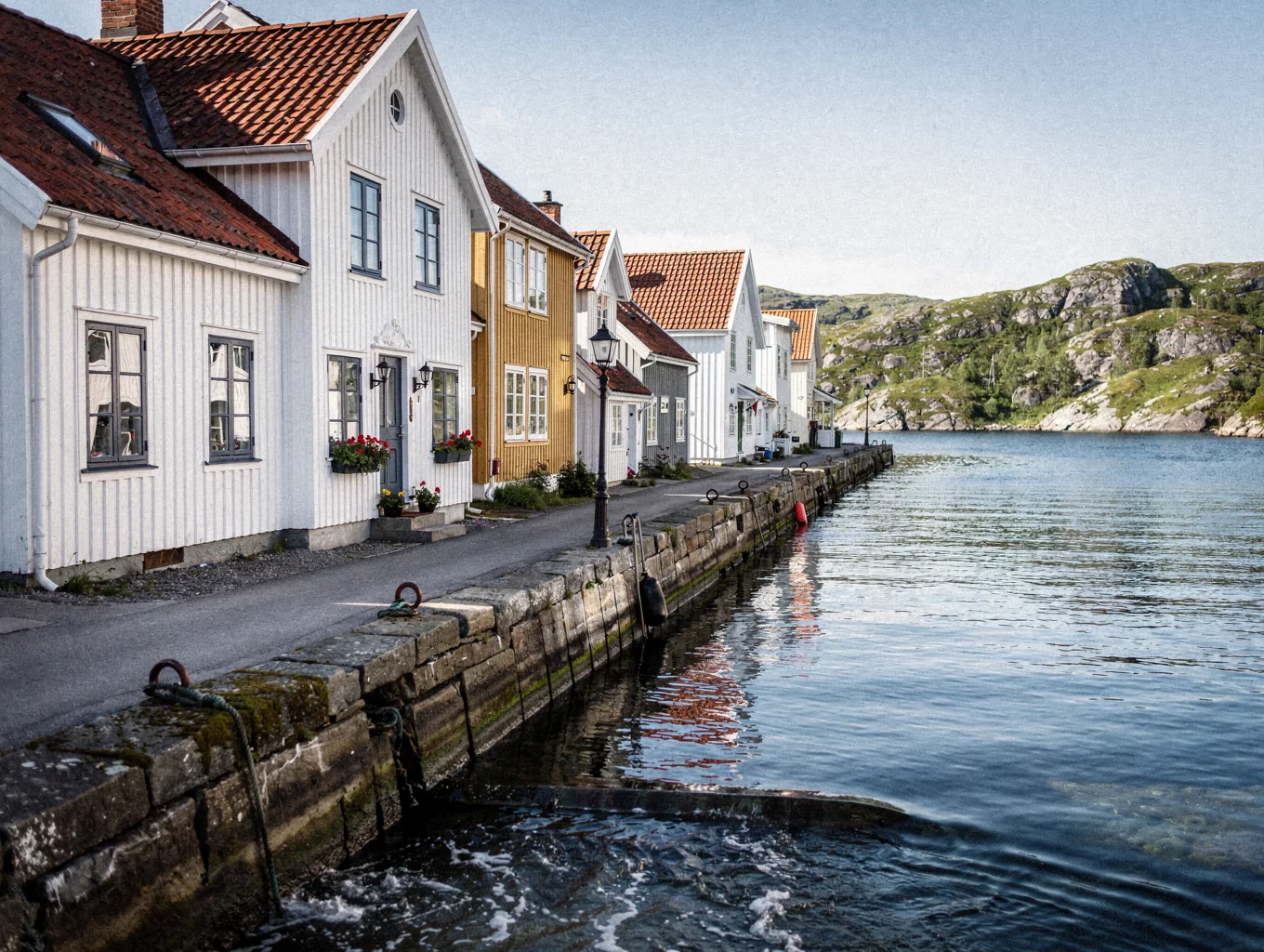 Scenic waterfront street with traditional Nordic timber architecture and serene coastal views