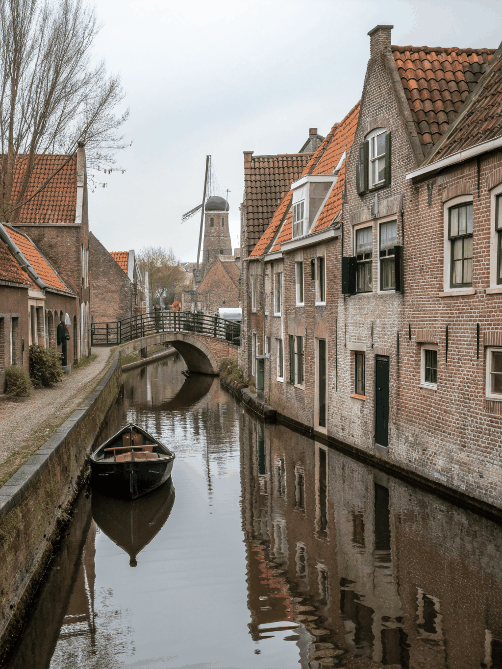 Medieval brick architecture and bridges reflected in the calm waters of Bruges Belgium