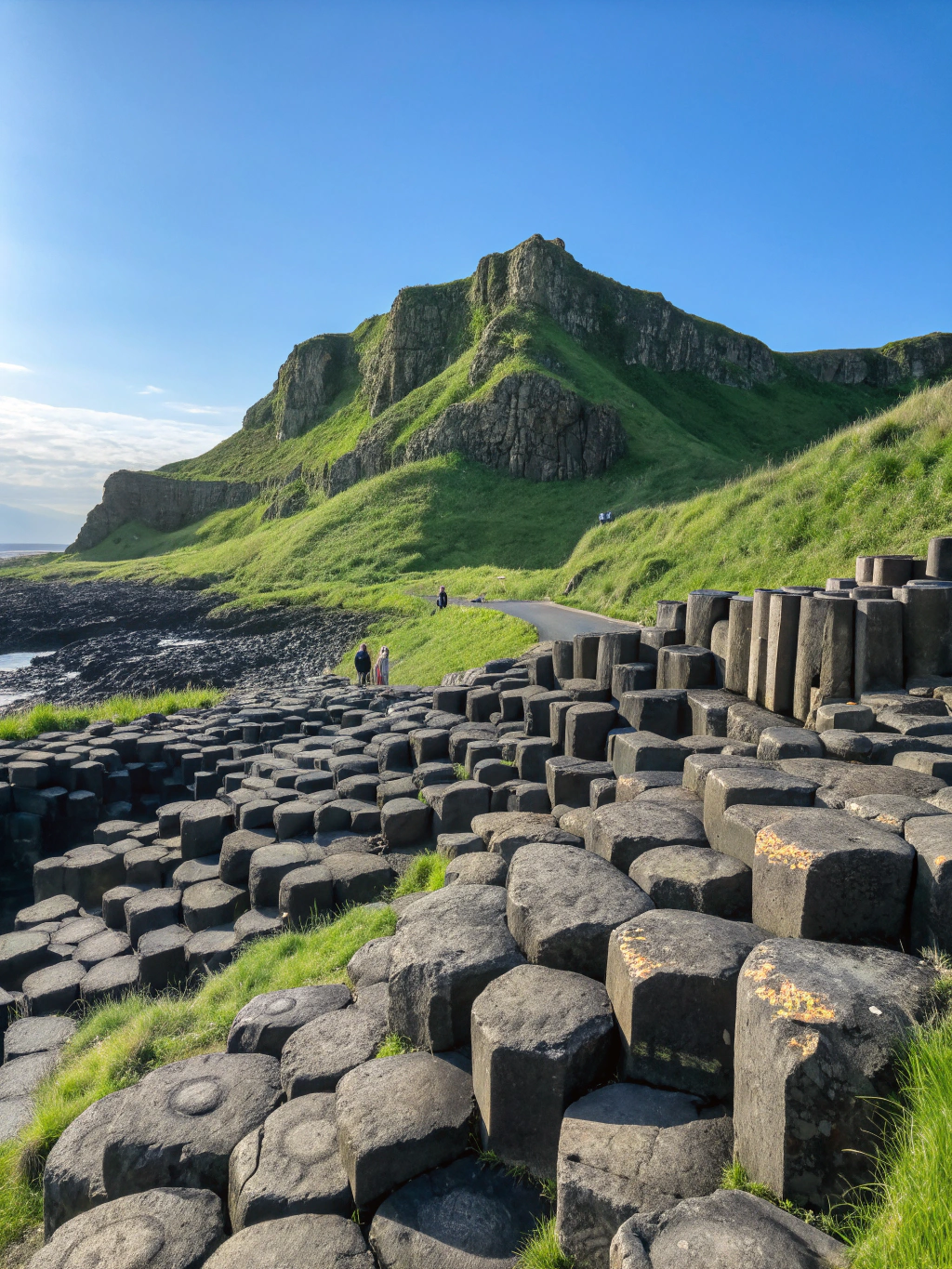 Hexagonal basalt columns meeting crashing sea waves at Giant's Causeway Northern Ireland