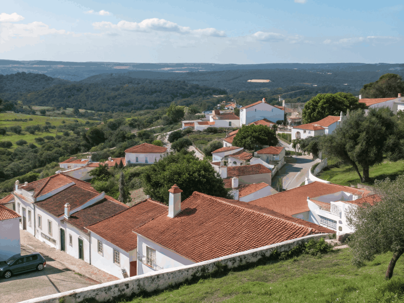 Hvitkalket befestet landsby med utsikt over olivenlunder i Portugal