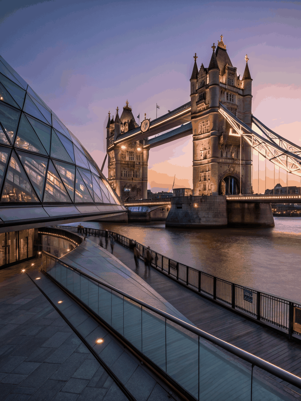 Iconic Tower Bridge illuminated over the River Thames at night with city lights in London