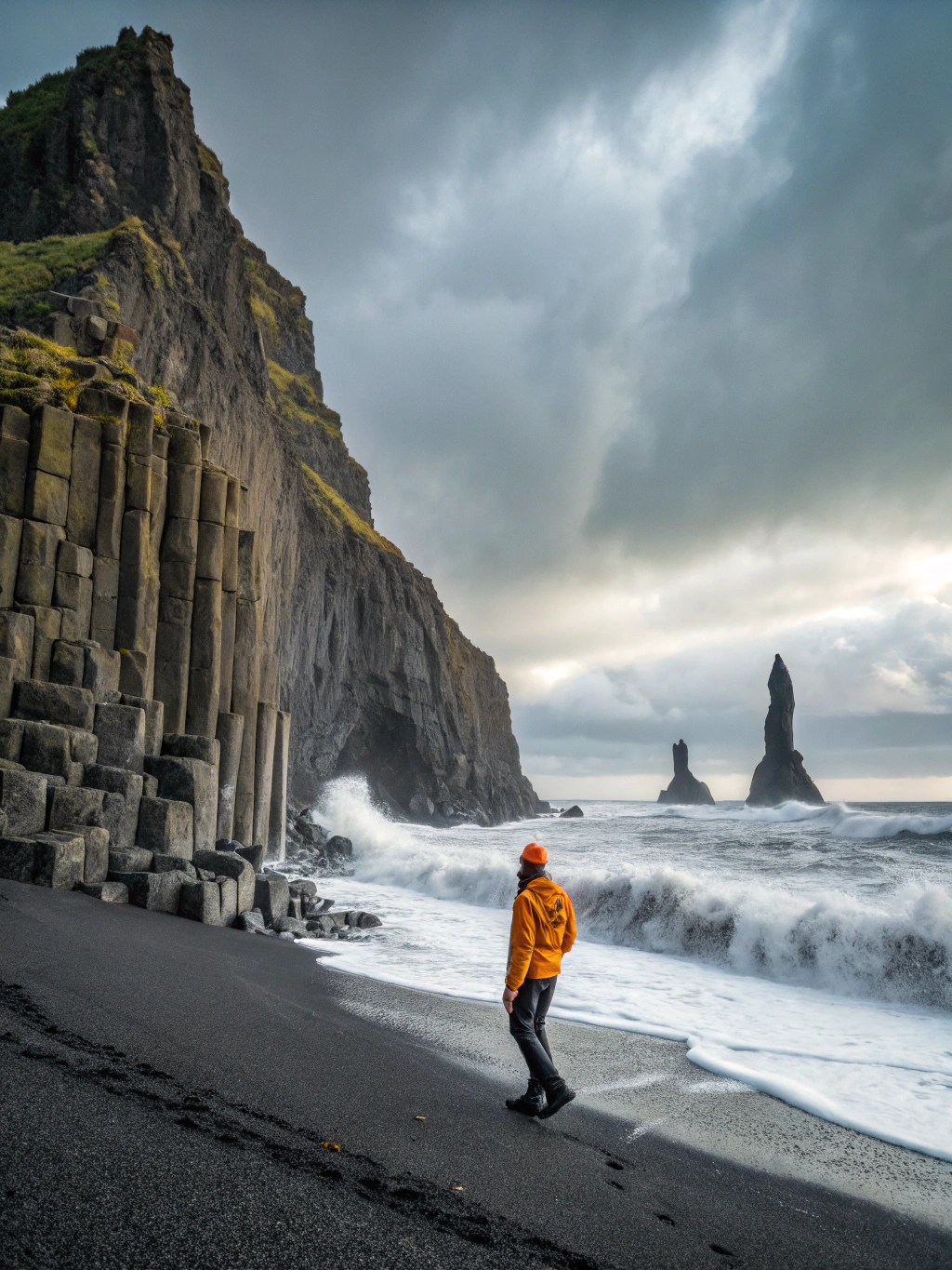 Geometric dark basalt sea columns and black volcanic sand on the Icelandic coast