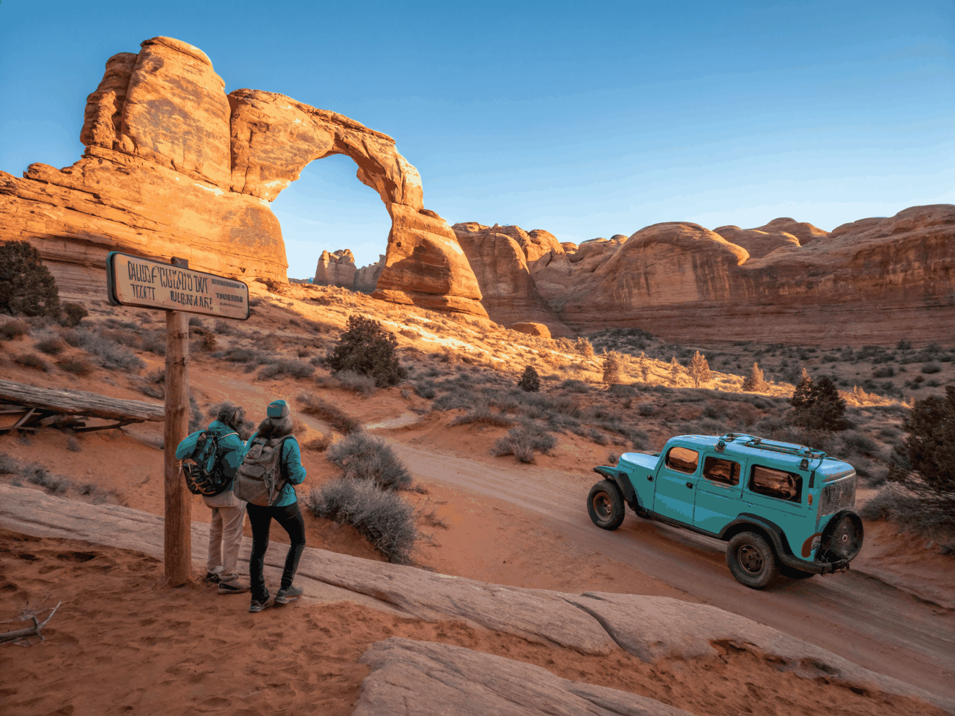 Isolated Delicate Arch perched on red sandstone slickrock at golden hour
