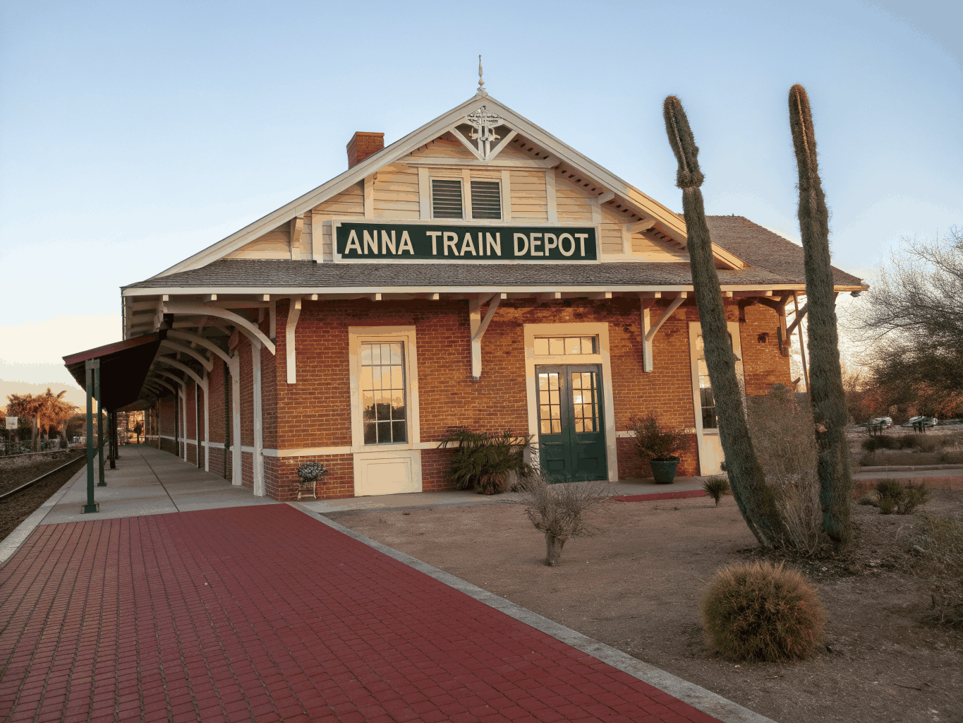 Historic Spanish Revival train depot and desert railway tracks under open Mojave sky in Barstow