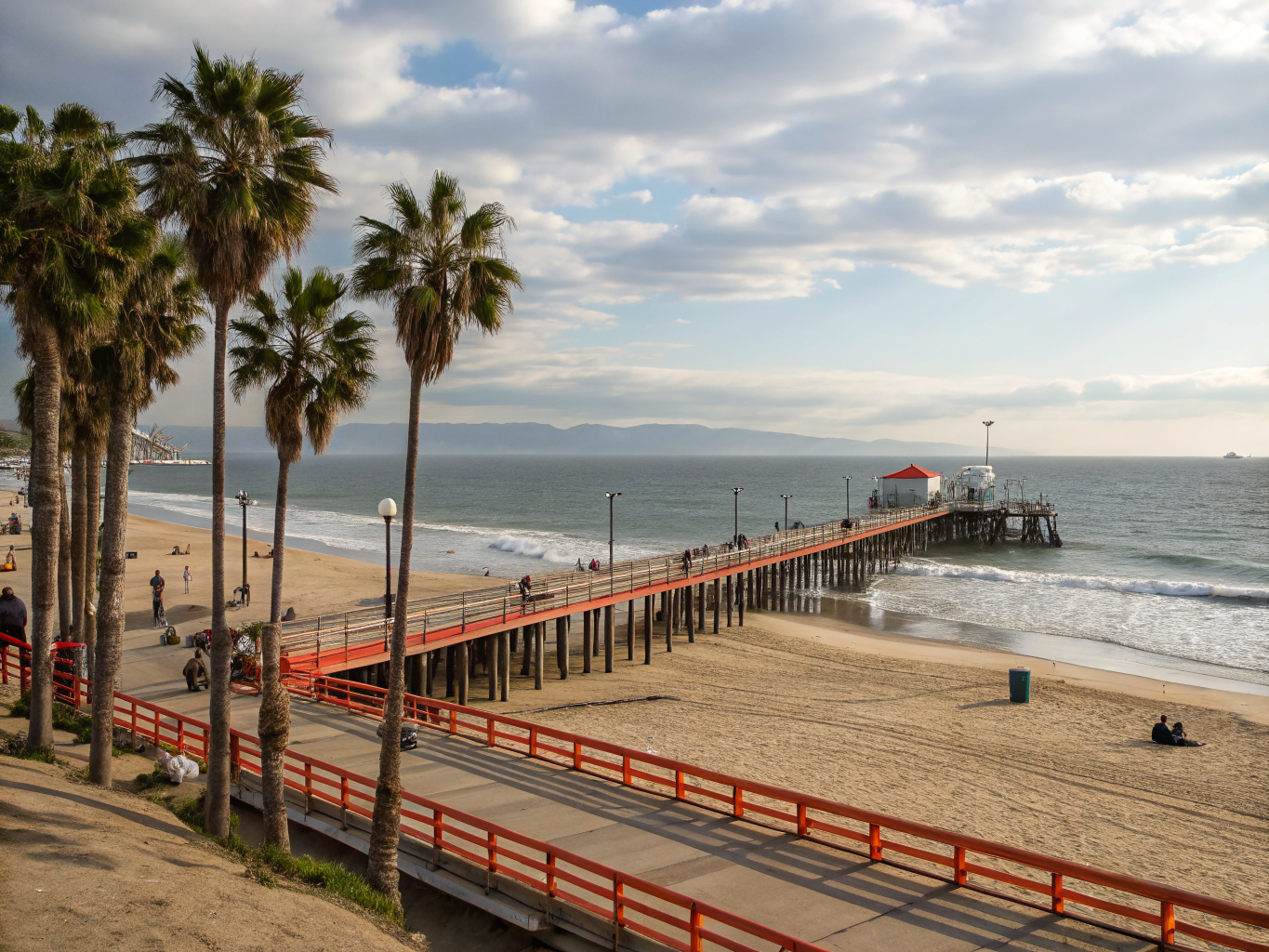 Route 66 End of the Trail commemorative sign on wooden Santa Monica Pier at sunset overlooking the Pacific