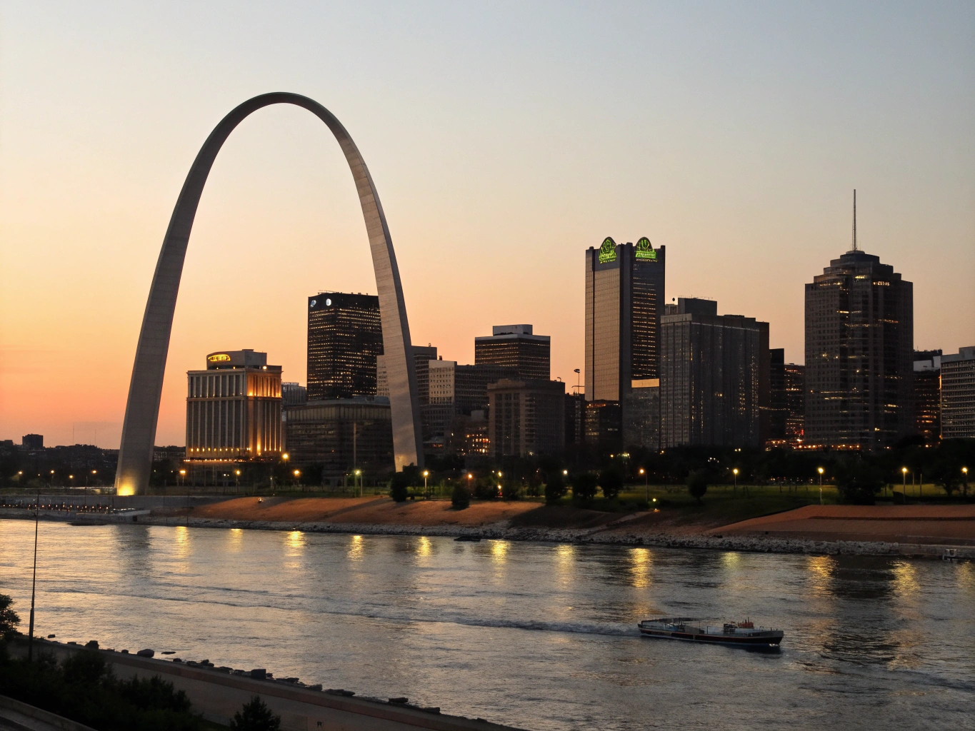 Soaring stainless steel Gateway Arch reflecting evening light by the Mississippi River